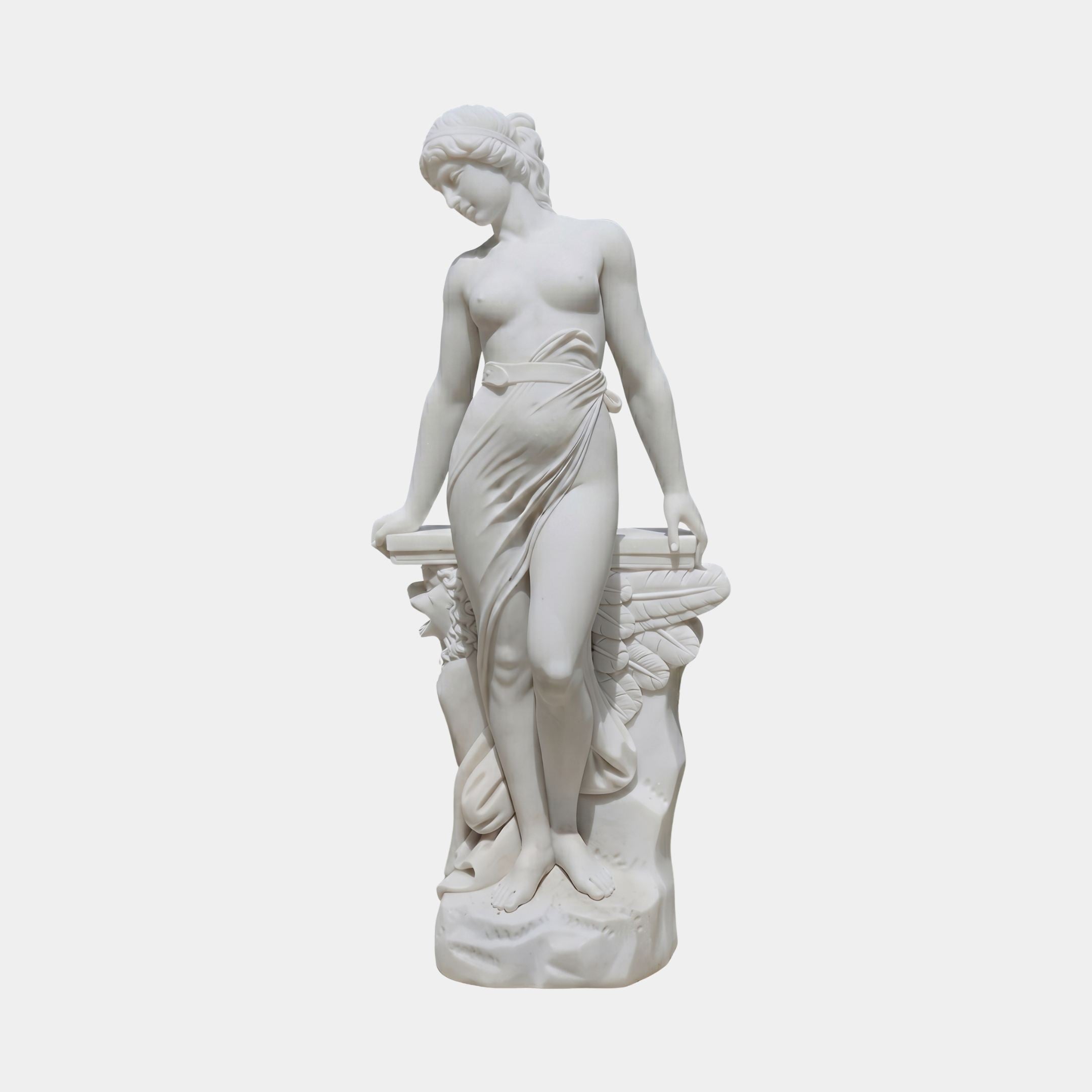 Venus Italica 120cm white marble sculpture by Giant Sculptures, depicting a draped female figure in a modest pose leaning against a plinth, on a plain background.