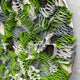 Close-up of the Giant Sculptures Rivora Green Ribbon Leather Circular 3D Wall Art, showing densely packed green, grey, and cream leather ribbons in wavy folds.