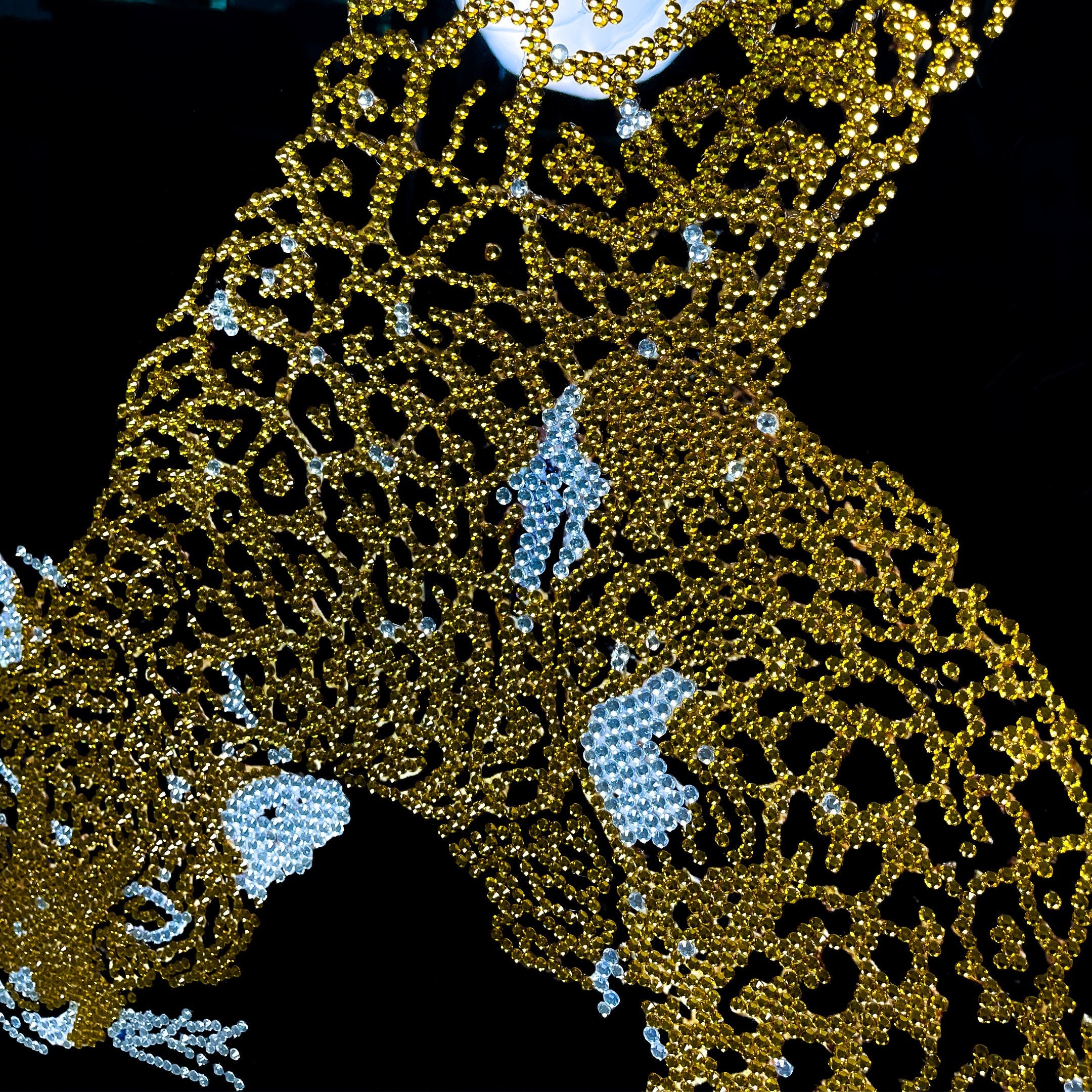 Close-up of the Giant Sculptures Glacia Dual Jaguar Crystal Hanging Framed Wall Art showing gold crystal-inlaid jaguar forms with pale blue accents on black.
