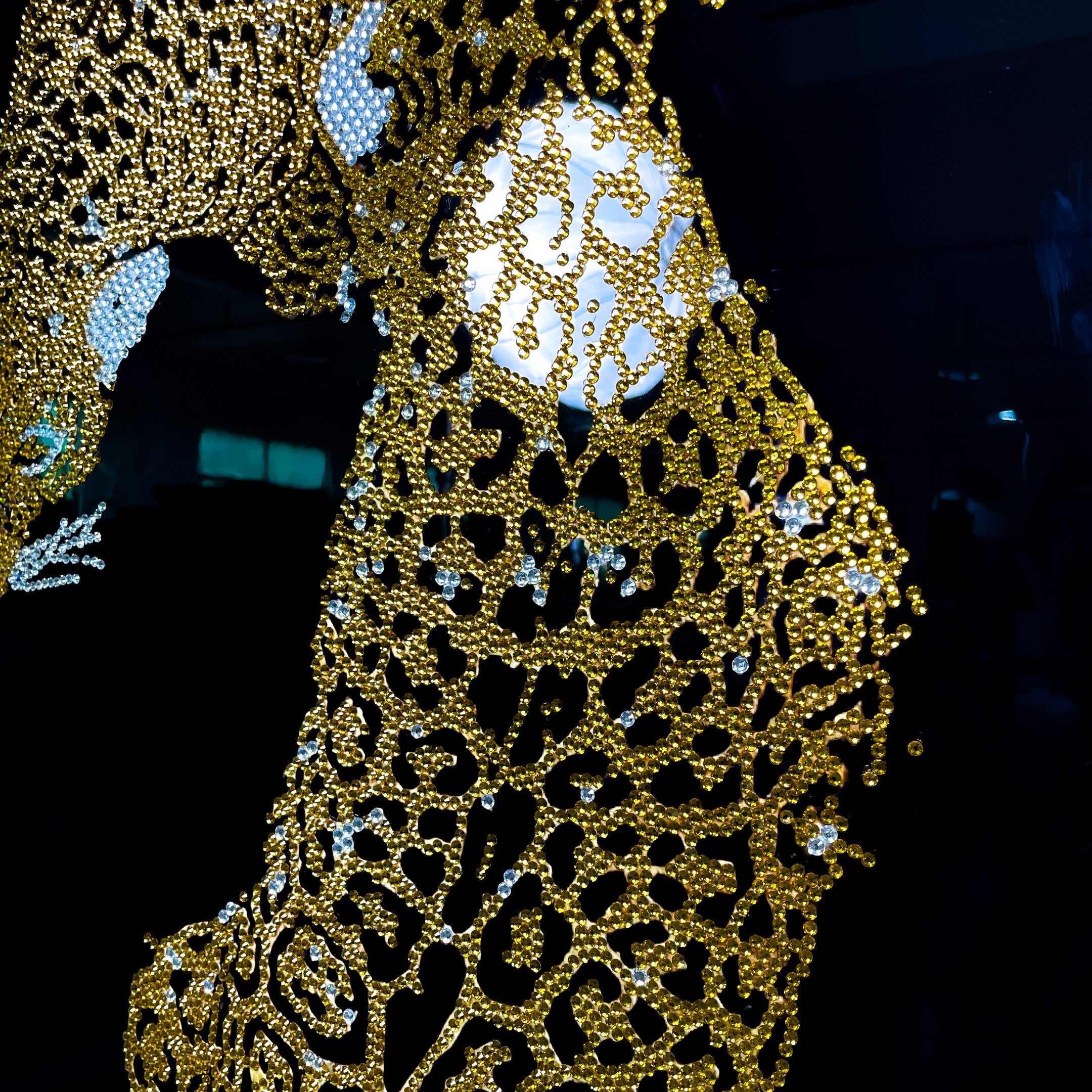 Close-up of the Giant Sculptures Glacia Dual Jaguar Crystal Hanging Framed Wall Art showing gold crystal-inlaid jaguar forms against a dark background with a glowing orb.