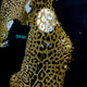 Close-up of the Giant Sculptures Glacia Dual Jaguar Crystal Hanging Framed Wall Art showing gold crystal-inlaid jaguar forms against a dark background with a glowing orb.