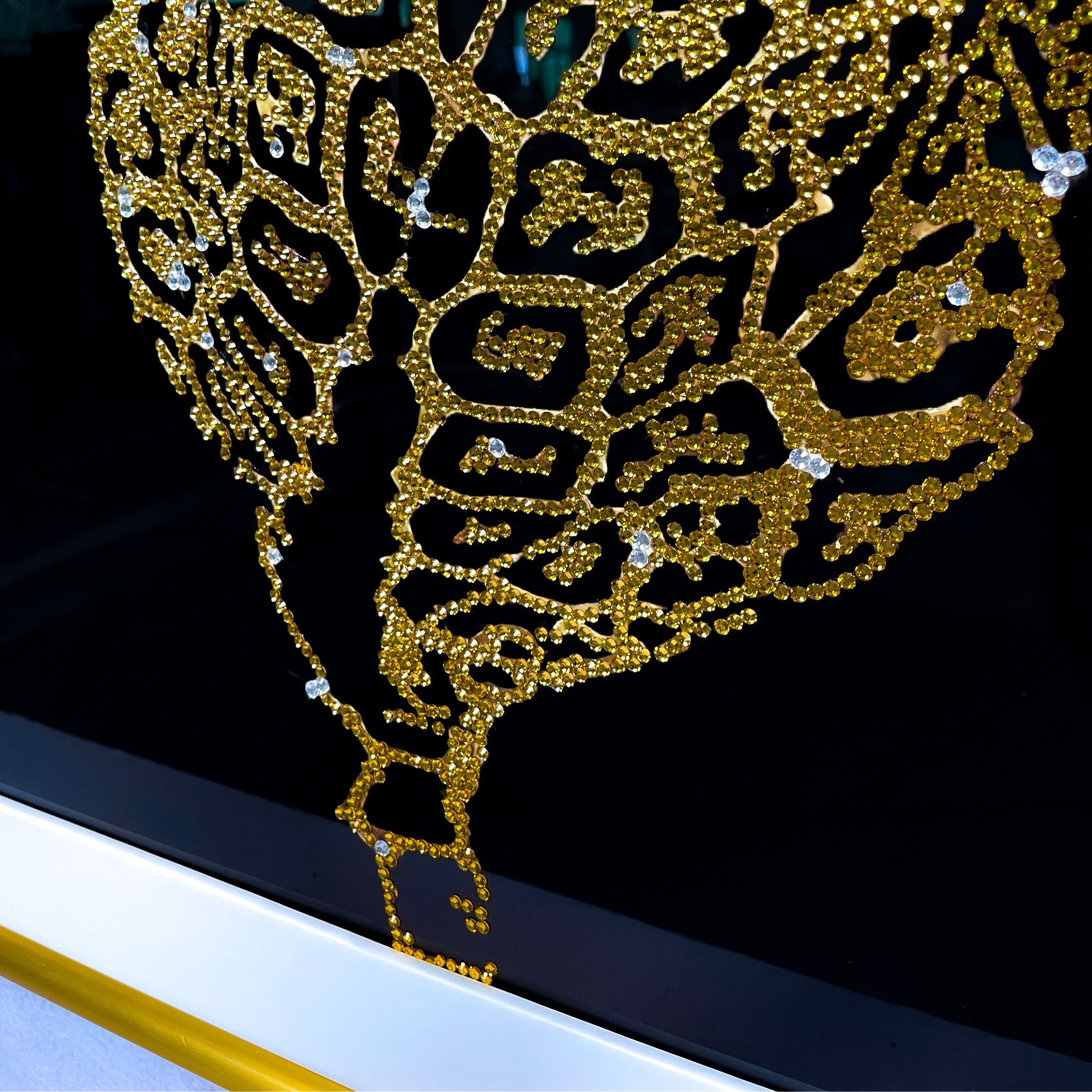 Close-up of the Glacia Dual Jaguar Crystal Hanging Framed Wall Art showing gold and clear crystal inlays tracing the jaguar's form against a dark panel.
