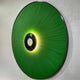 Vanguard Jade Surge Leather 3D LED Wall Art shown at an angle, with jade-green leather rays radiating from a black disc, backlit by warm LED glow.