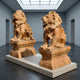 Two impressive Giant Lion Yellow Marble Outdoor Sculptures (120cm) by Giant Sculptures sit on rectangular pedestals in a modern, well-lit gallery—an inspiring and contemporary interpretation of classic entrance decor.