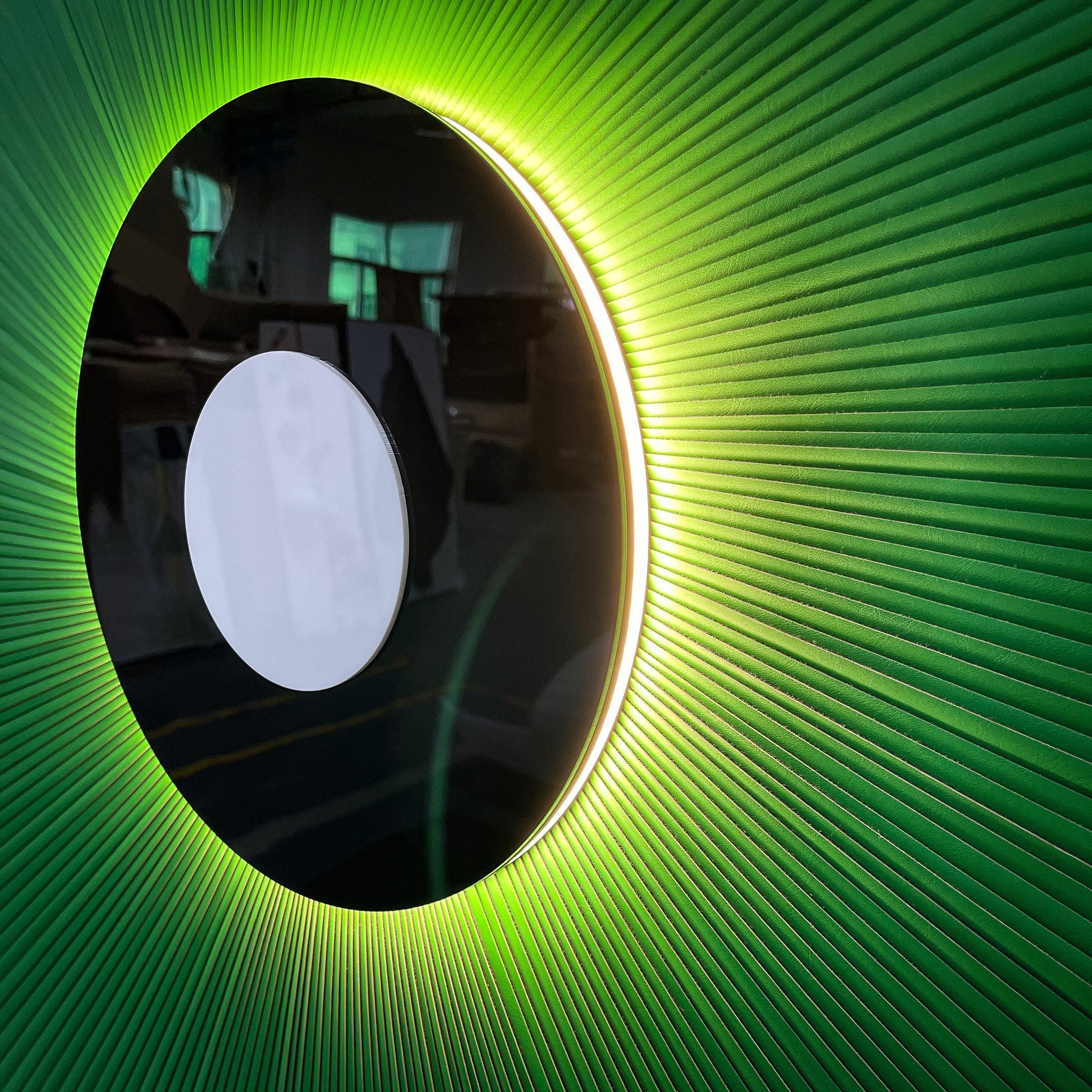 Close-up side view of the Vanguard Jade Surge Leather 3D LED Wall Art showing jade-green leather rays radiating from a black disc with white centre and warm LED backlight glow.