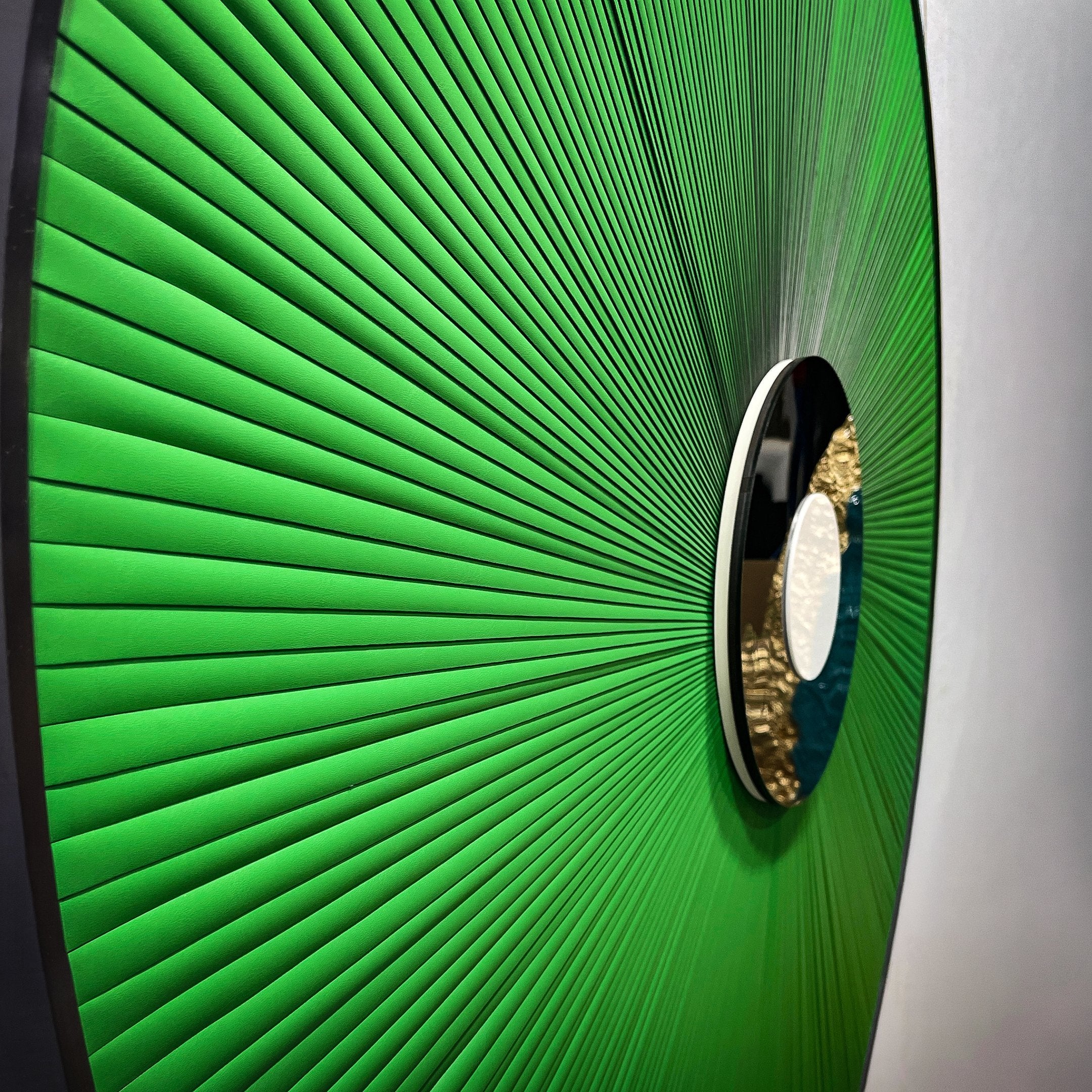 Close-up side view of the Giant Sculptures Vanguard Jade Surge Leather 3D LED Wall Art showing jade-green leather rays radiating from a black-and-white central disc.