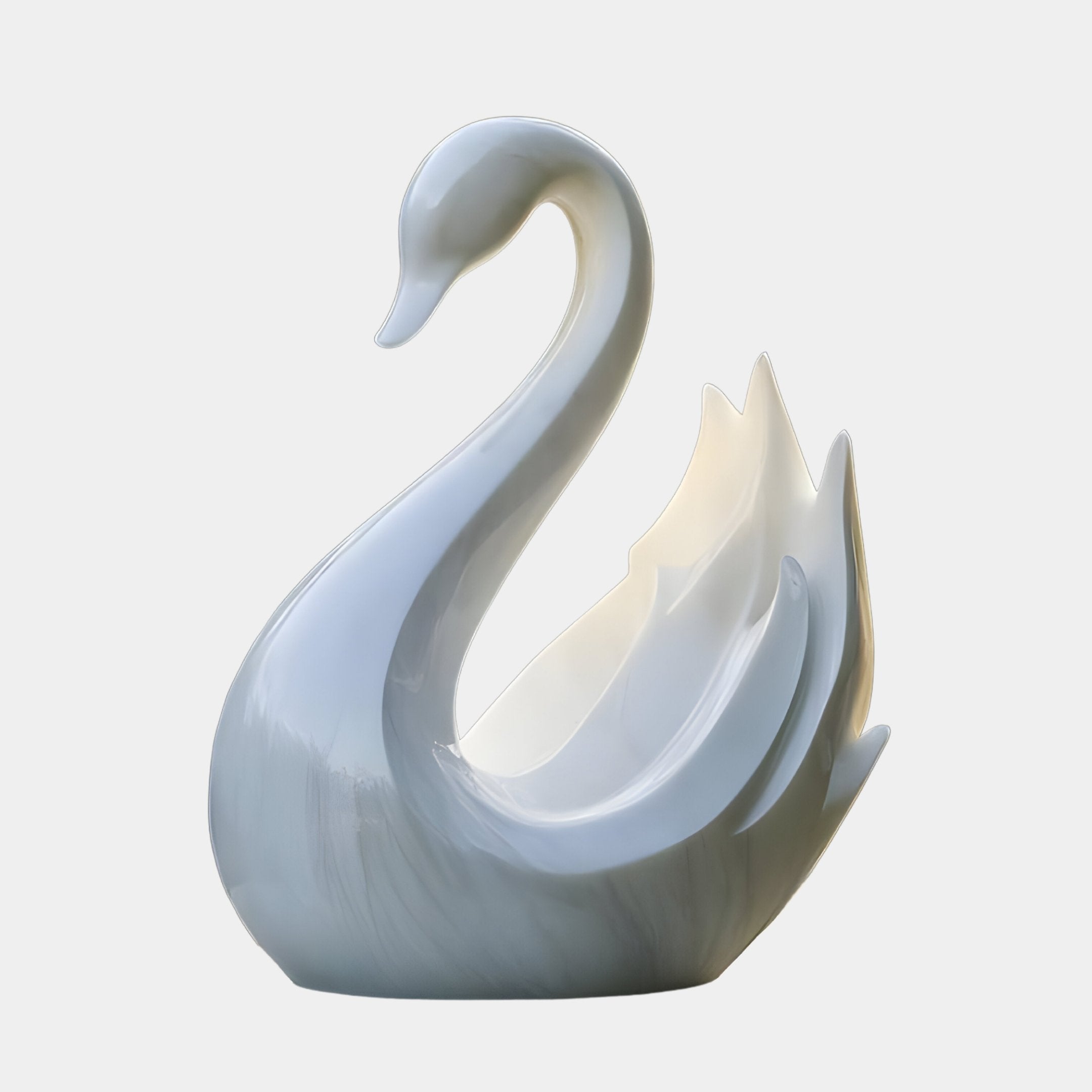 The Serene Swan White Marble Outdoor Sculpture by Giant Sculptures features a sleek, elongated-neck swan with stylized wings. Its glossy finish reflects light beautifully, emphasizing the sculptures elegant curves.