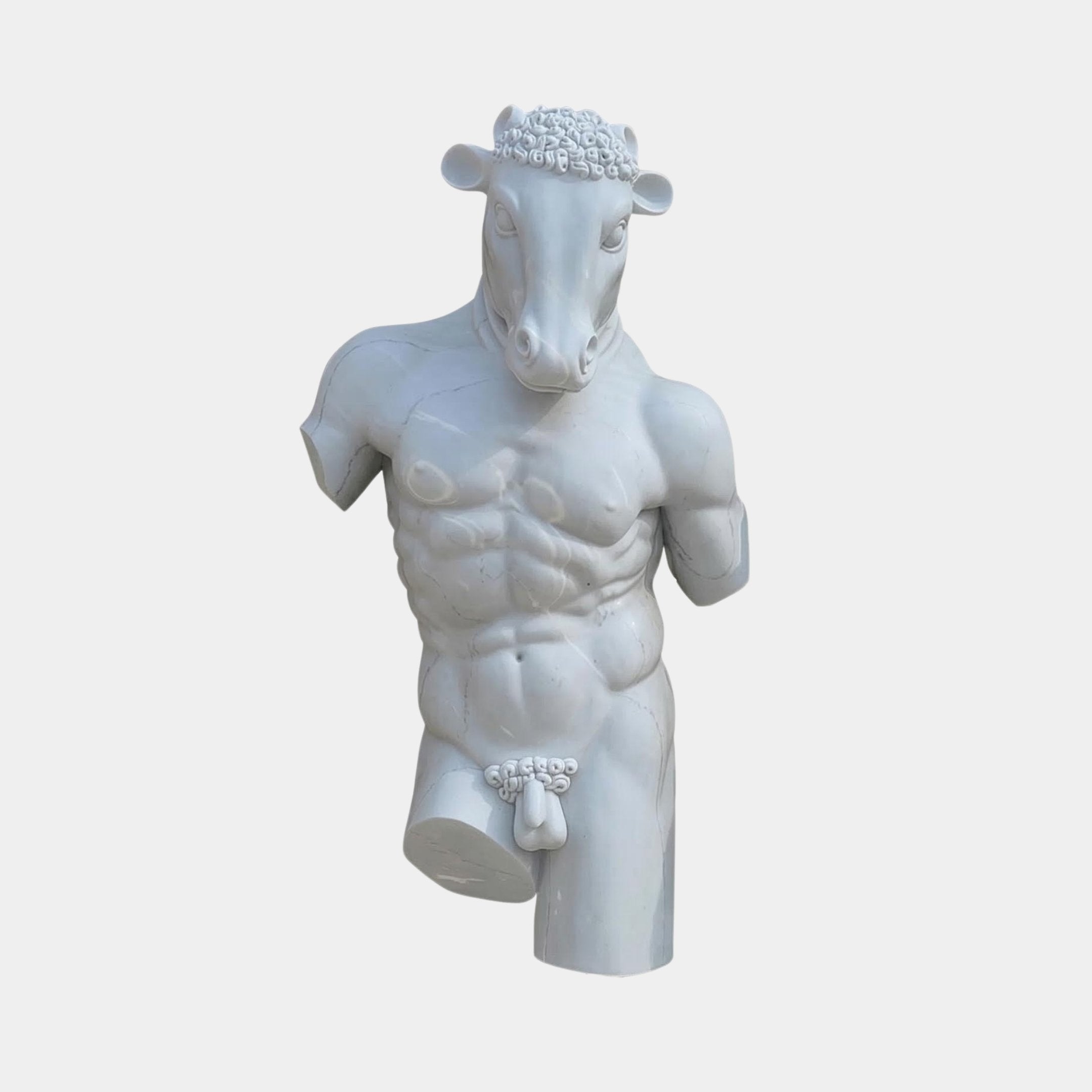 The Bacchus Marble Torso Sculpture - 120cm by Giant Sculptures features a muscular, armless male with a bull’s head and floral details on head and groin, set against a plain white background—an intriguing animal head sculpture.