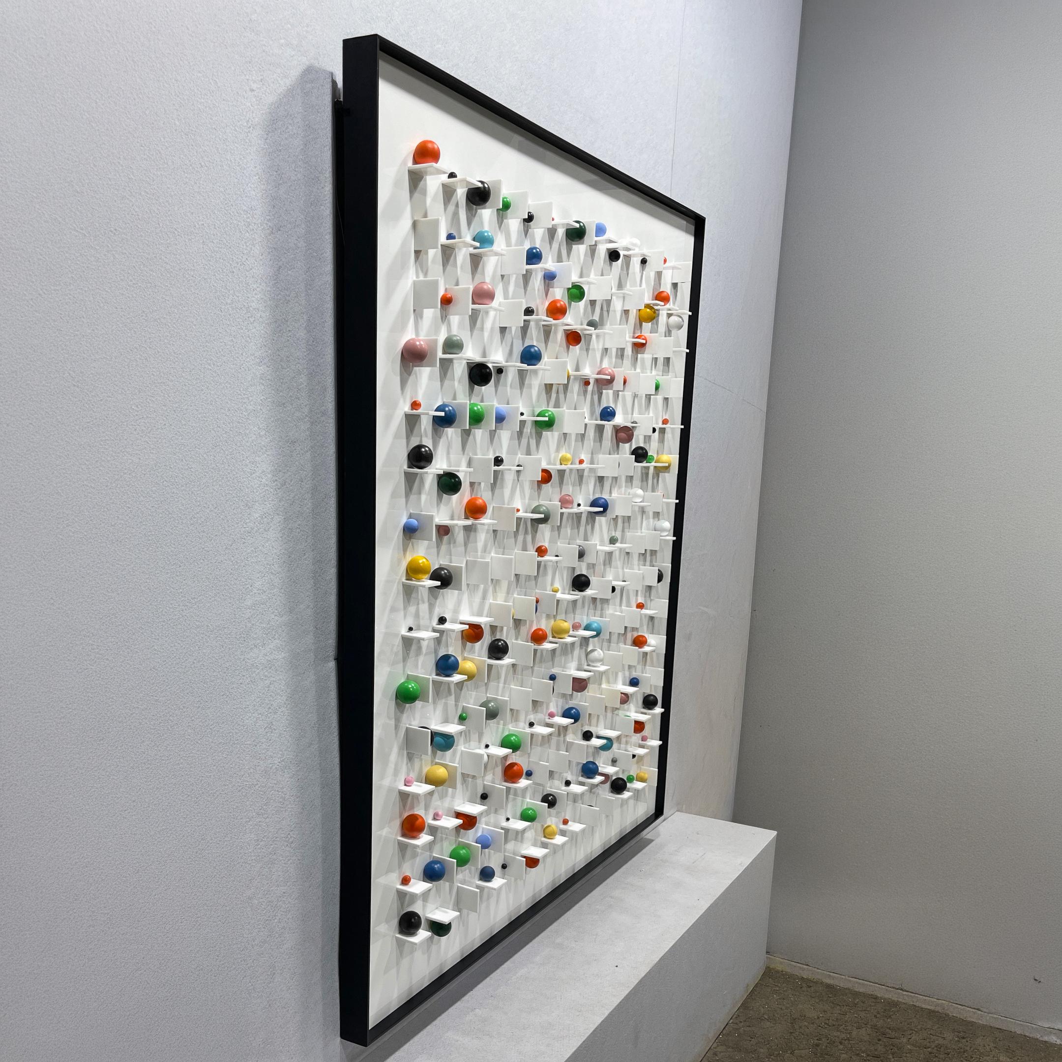 Angled side view of the Aeris Multi-Coloured Wooden Sphere 3D Wall Art by Giant Sculptures, showing pegged colourful spheres projecting from a white grid in a black frame.