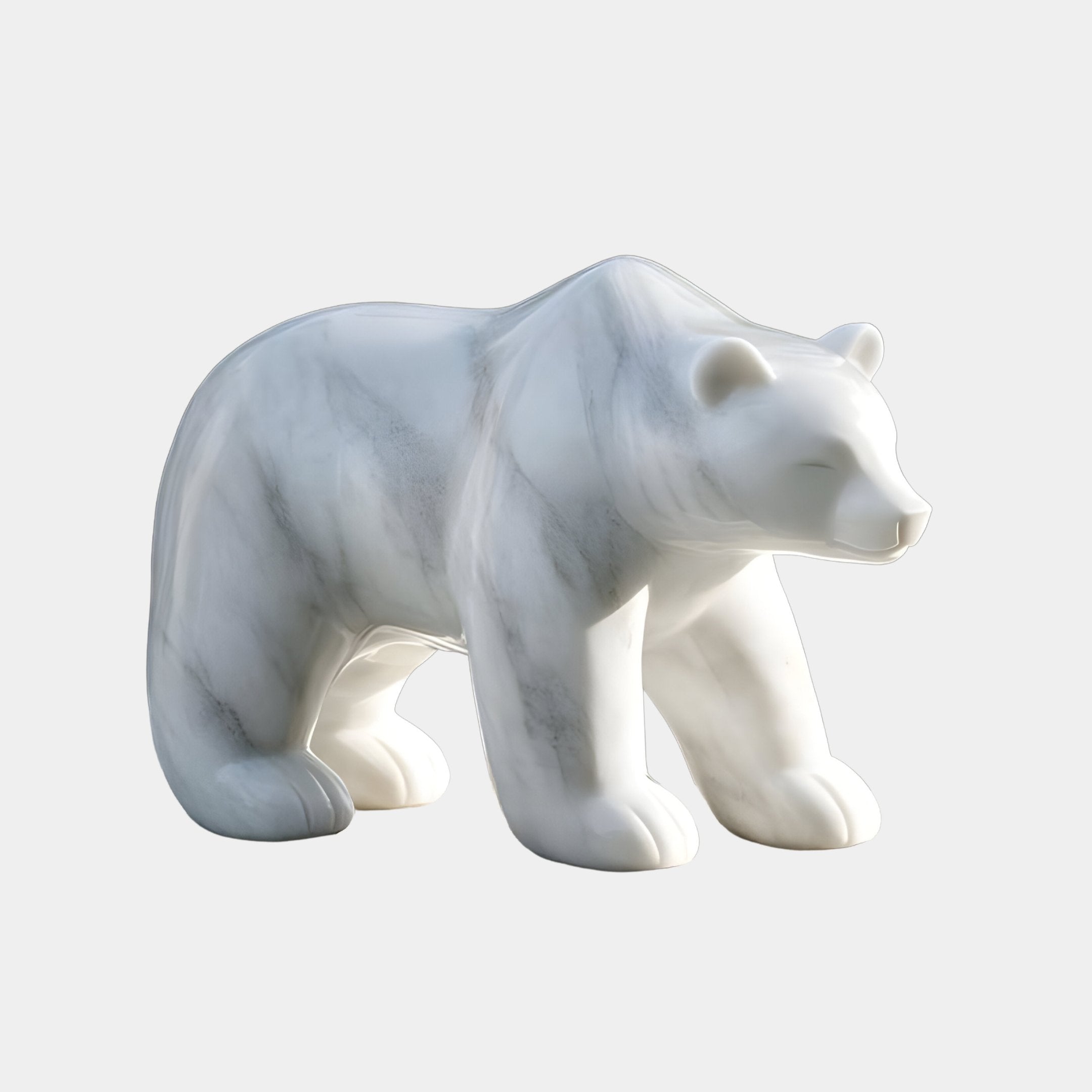 The Arctic Polar Bear White Marble Outdoor Sculpture by Giant Sculptures is a 50cm piece depicting a walking bear on a light gray background. It showcases smooth, curving lines polished to highlight its graceful contours with subtle gray veining in the high-calibre marble.