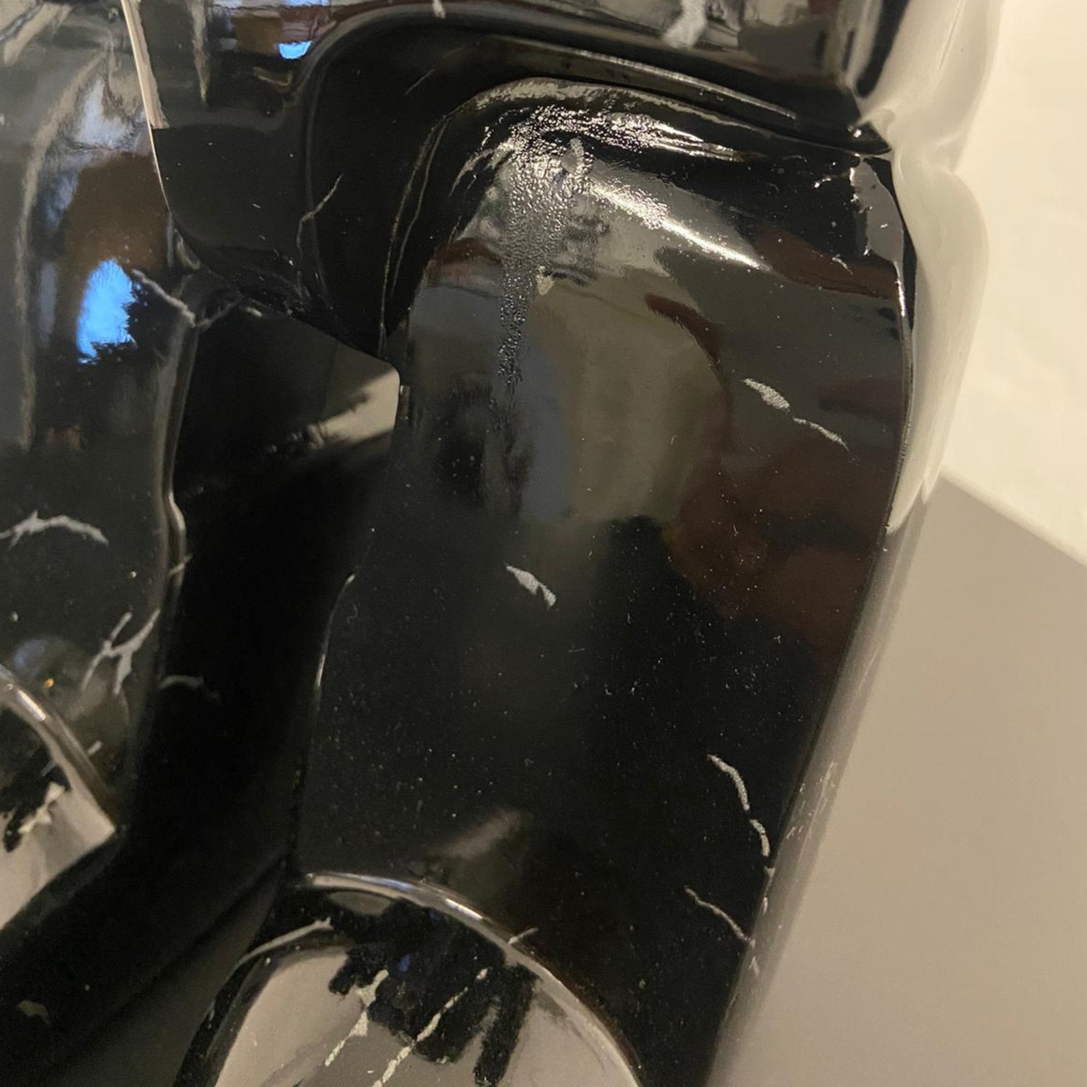 Close-up of the Black Stone Bear Sculpture - 50cm (Ex Display) by Giant Sculptures, featuring glossy black surfaces with white streaks and geometric curves—an eye-catching modern decor piece.