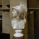 Athena Marble Bust Sculpture (Plumed Helmet) - 65cm by Giant Sculptures shown in left profile on a turned round pedestal, displayed against classical stone architecture.