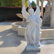 The Harvest Sheaf Angel Marble Outdoor Sculpture - 200cm by Giant Sculptures, a white statue of a winged female figure with a cornucopia, serves as an elegant garden focal point among other stone sculptures and architectural elements like columns and arches in the sunny outdoor scene.