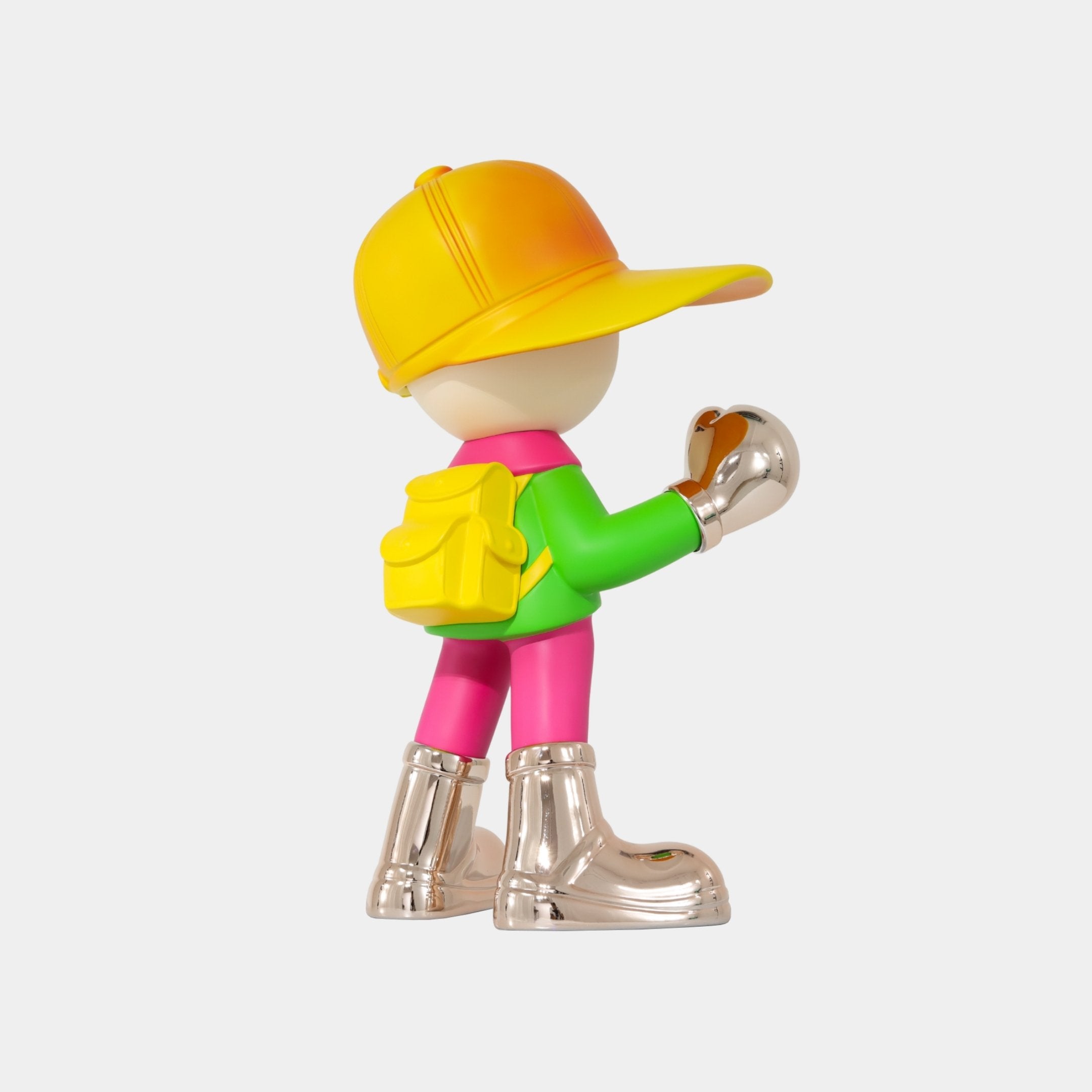 The Giant Sculptures Electroplated Boots & Fist Sunset Brimble Figure (52cm) features a decorative boy character with a large yellow cap, bright green shirt, pink pants, and shiny boots posed against a plain white background.