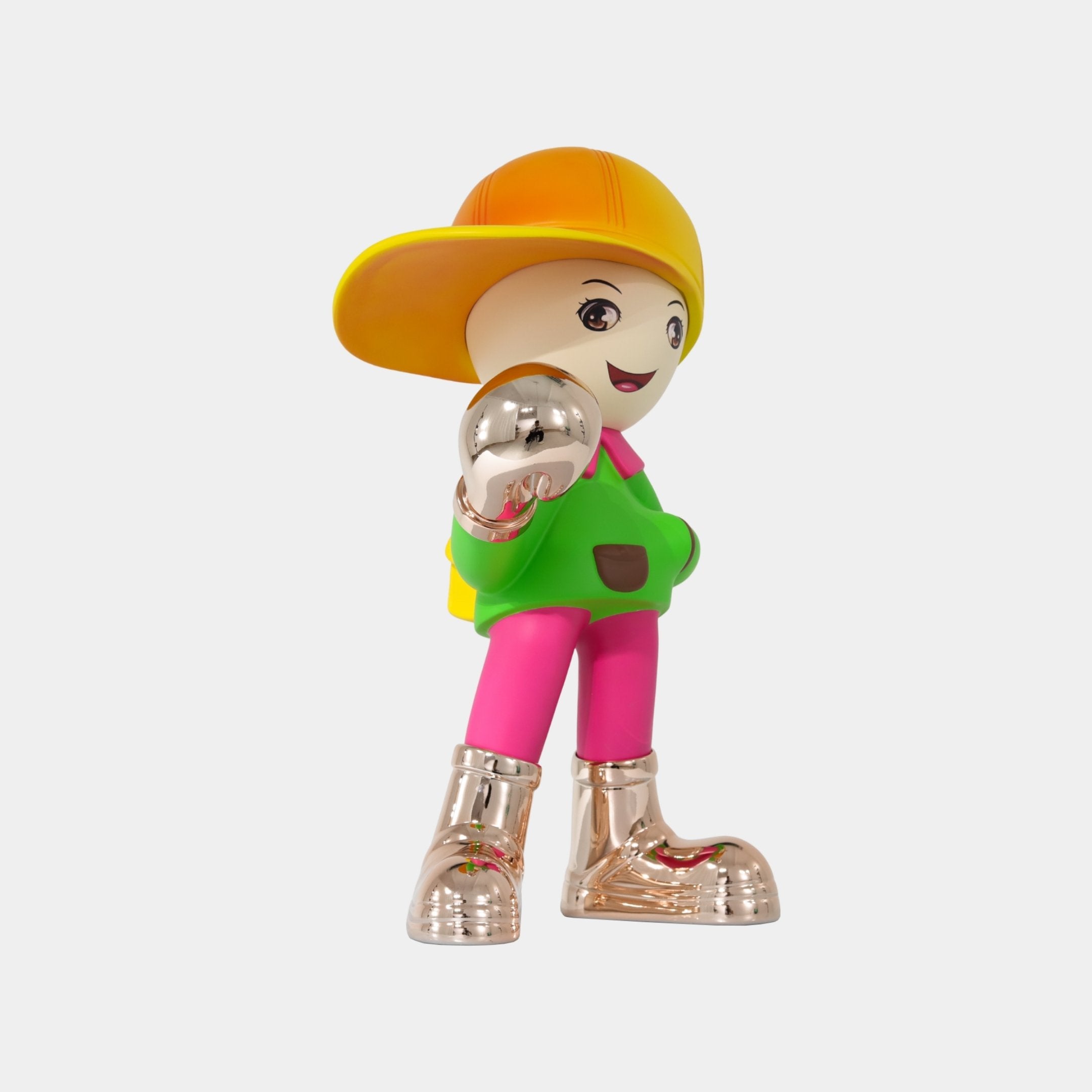 The Electroplated Boots & Fist Sunset Brimble Figure by Giant Sculptures features a cheerful cartoon boy with a yellow hat, green shirt, pink pants, and shiny metallic boots, standing smiling and pointing forward. Size: 52cm.