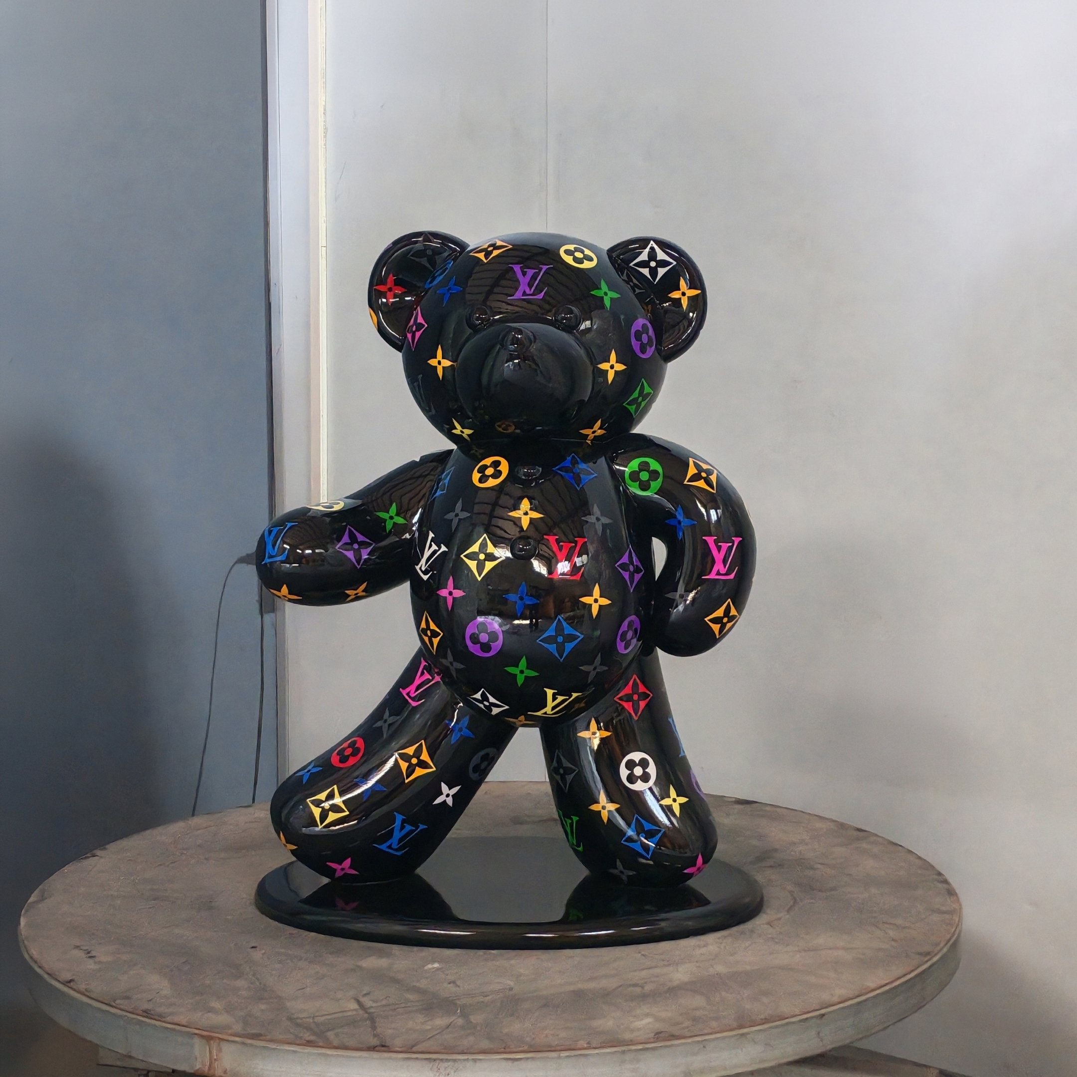 The Gacko Multicoloured LV Bear Sculpture by Giant Sculptures stands 70cm tall, featuring a glossy, cartoon-like finish with vibrant Louis Vuitton logos—perfect for adding pop art flair to modern interiors.