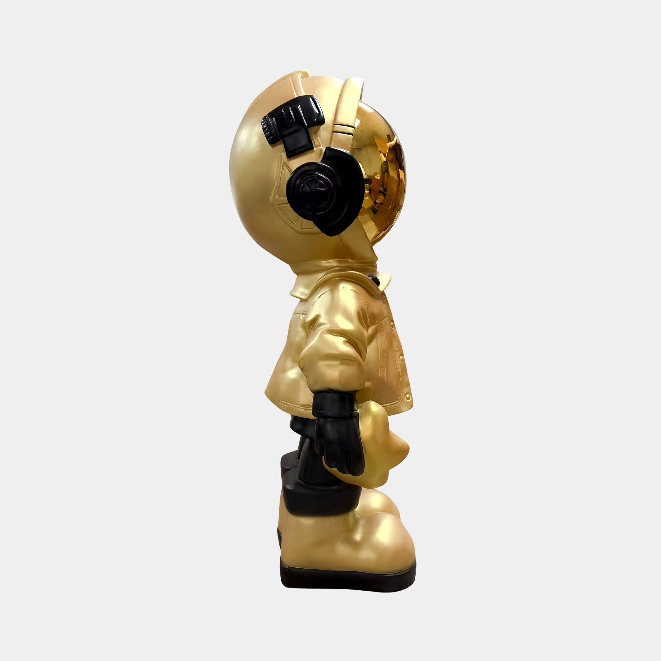 The Giant Sculptures Celestial Gold Astronaut Beats Figure - 36cm stands upright with a reflective gold visor, black headphones, gloves, boots, and jacket—an eye-catching space-inspired décor piece for any plain light background.