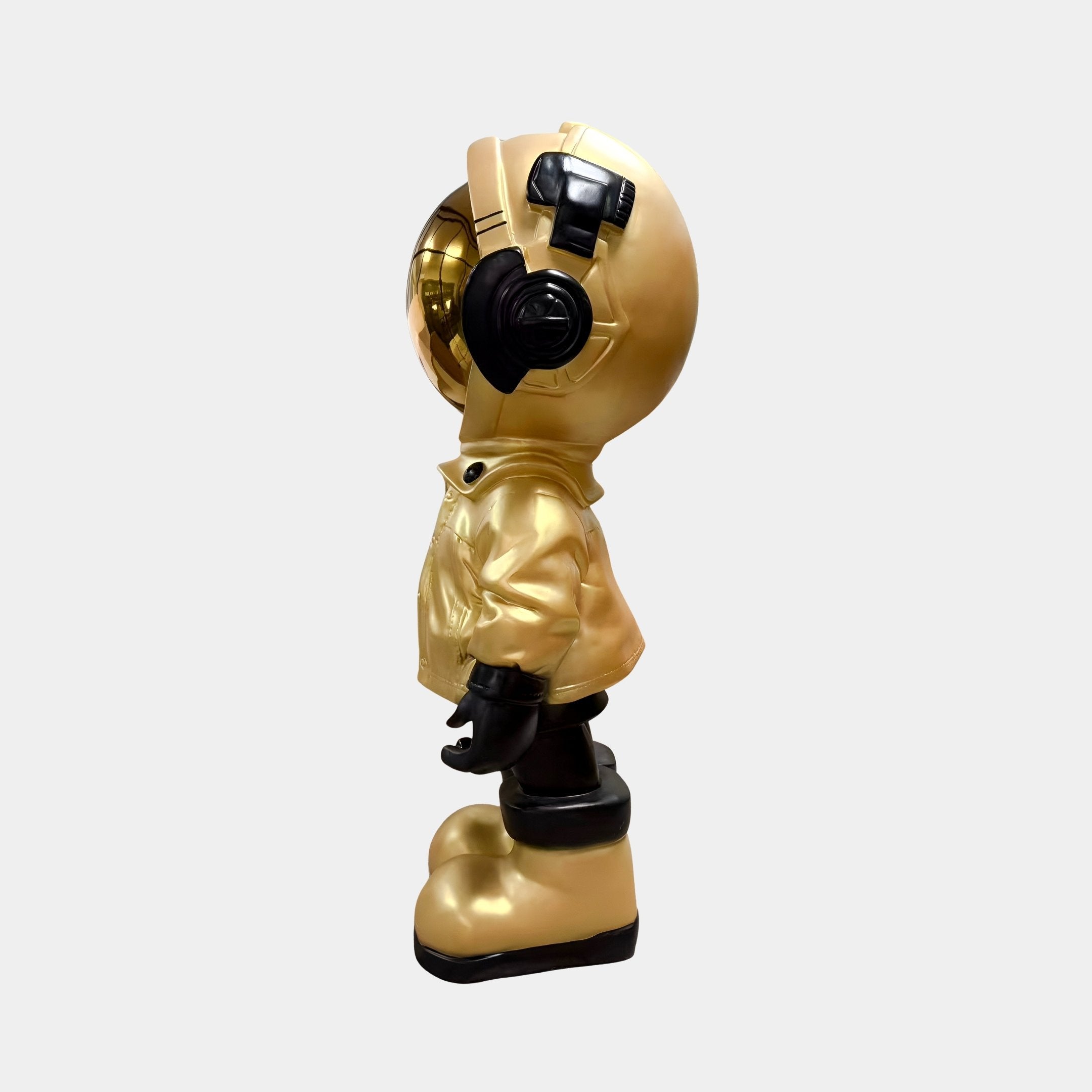The Giant Sculptures Celestial Gold Astronaut Beats Figure - 36cm features a reflective gold visor, headphones, and a jacket, standing upright and facing left—ideal for adding space-inspired style to any décor.