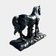 The Majestic Horse Black Marble Outdoor Sculpture - 220cm by Giant Sculptures features a polished equestrian design on a textured base, viewed from behind and slightly to the side, showcasing detailed craftsmanship and a naturalistic pose.