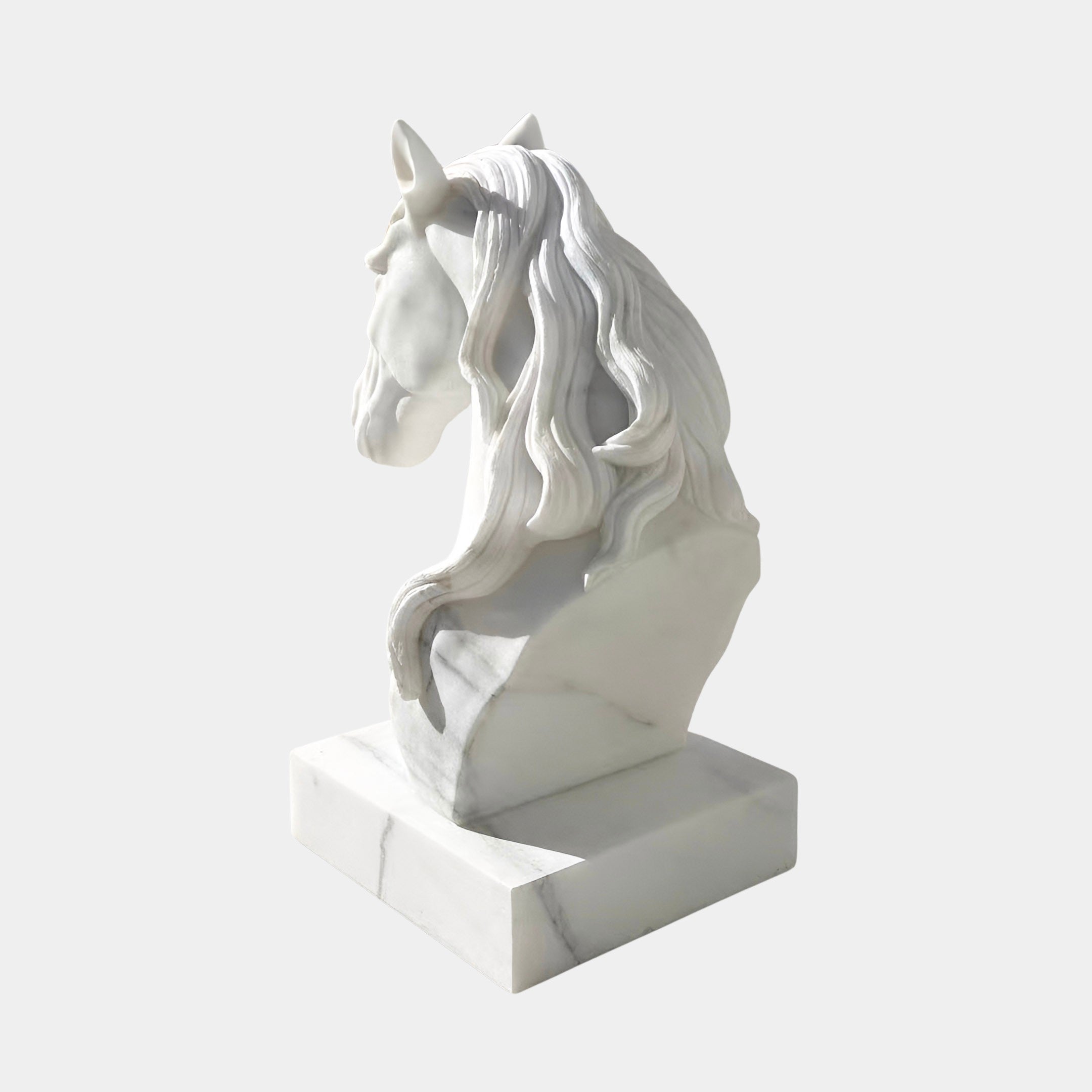The Graceful Horse Head White Marble Outdoor Sculpture (60cm) by Giant Sculptures features a flowing mane and sits on a rectangular base, viewed from the back left—an elegant equestrian accent against a plain light background.