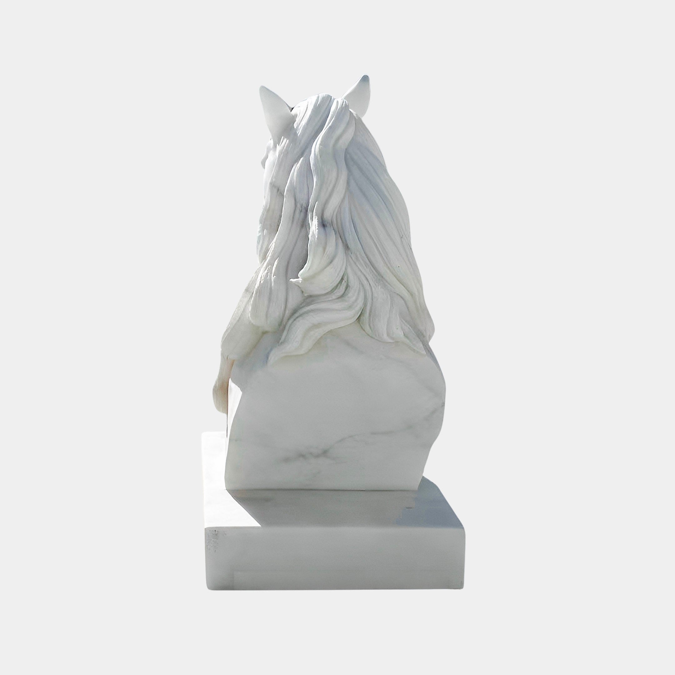 The Graceful Horse Head White Marble Outdoor Sculpture (60cm) by Giant Sculptures features an elegant equestrian design with a flowing mane, making it a striking accent on its rectangular base against a plain background.
