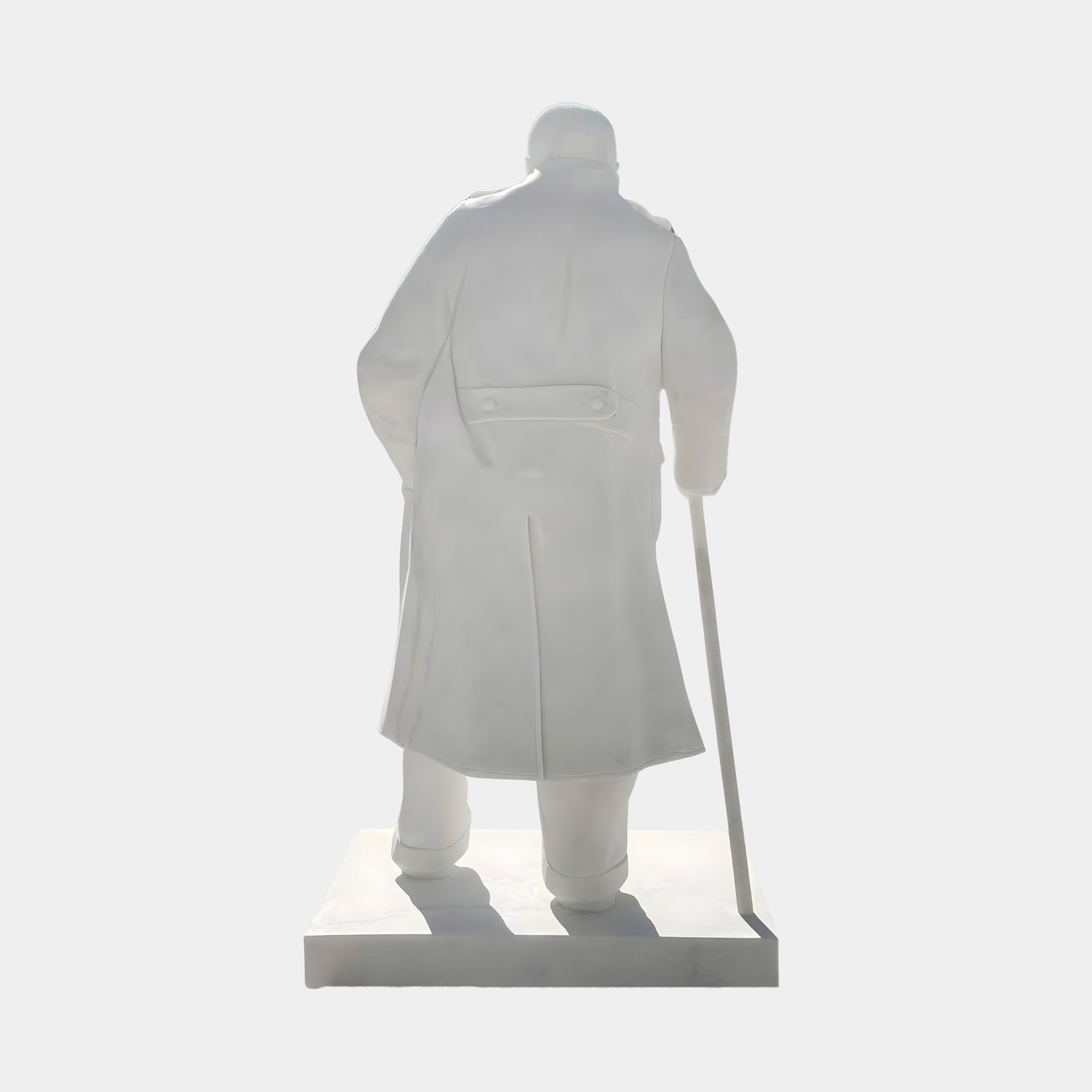 The Winston Churchill Marble Outdoor Sculpture by Giant Sculptures stands 195cm tall, featuring Churchill in a long coat holding a cane, viewed from behind on a rectangular base against a plain background.