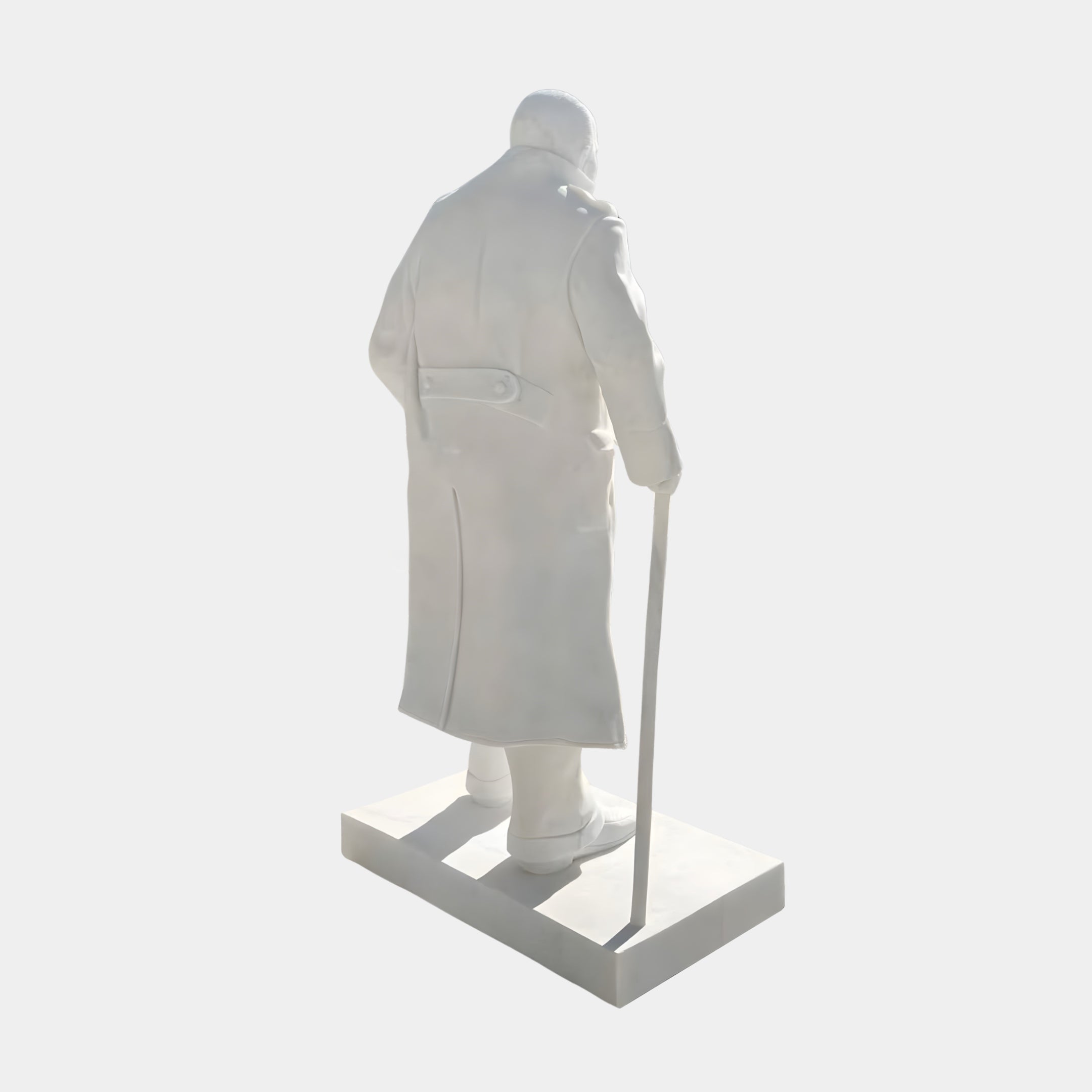 The Winston Churchill Marble Outdoor Sculpture - 195cm by Giant Sculptures features a white marble figure in a long coat holding a cane, viewed from behind on a rectangular base—evoking the iconic Churchill statue.