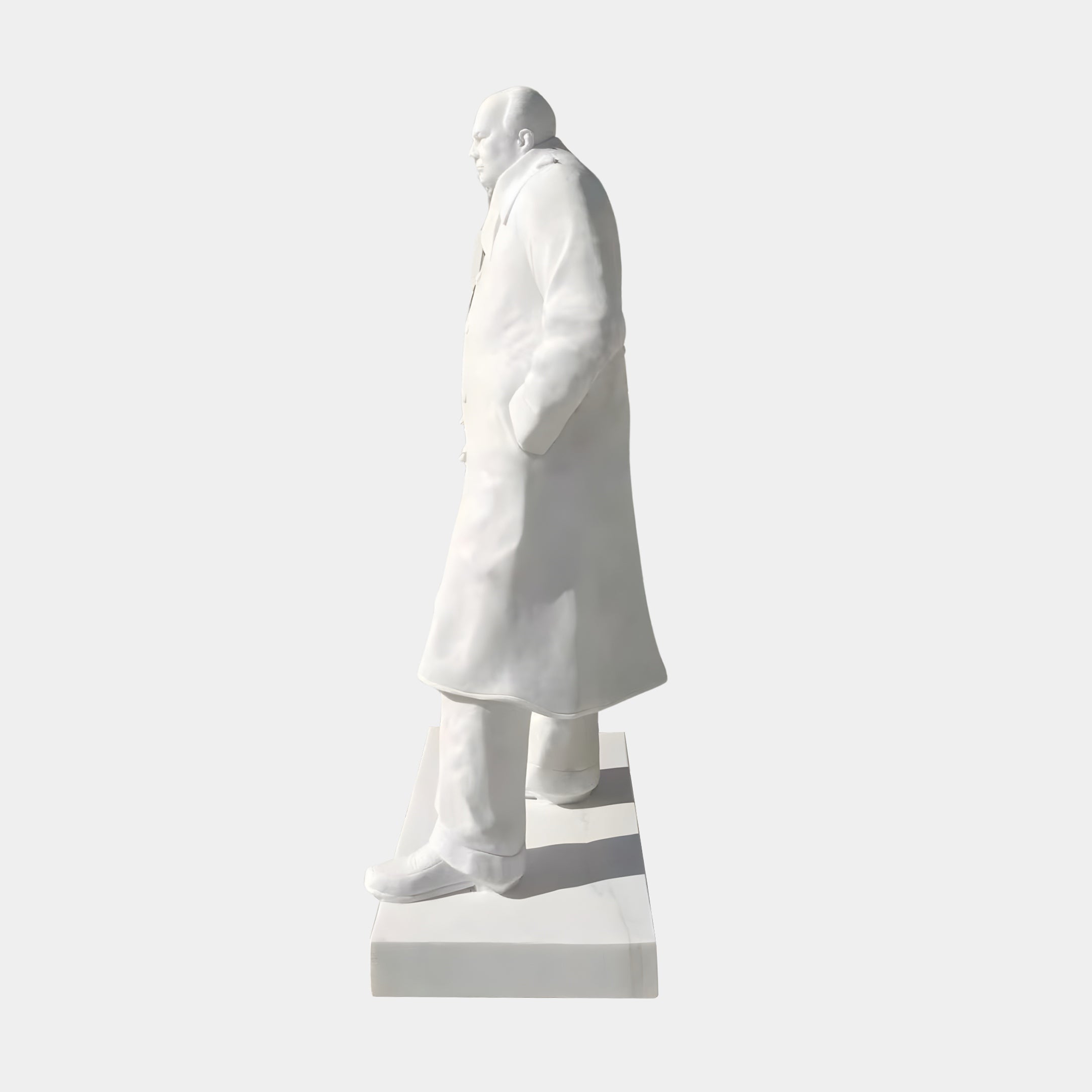 The Winston Churchill Marble Outdoor Sculpture by Giant Sculptures stands 195cm tall, depicting Churchill in a long coat with one hand in his pocket, profiled on a rectangular base for outdoor display.