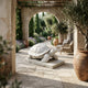The Longevity Tortoise Marble Outdoor Sculpture (80cm) by Giant Sculptures adds timeless charm to a Mediterranean-style garden patio, surrounded by terracotta pots, lush greenery, and arched walkways.
