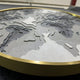 The Terranova Earth Green Round Wood Carving 3D Wall Art by Giant Sculptures showcases textured gray and white surfaces with a metallic gold edge, depicting parts of Europe, Africa, and Asia in an elegant nature-inspired design.