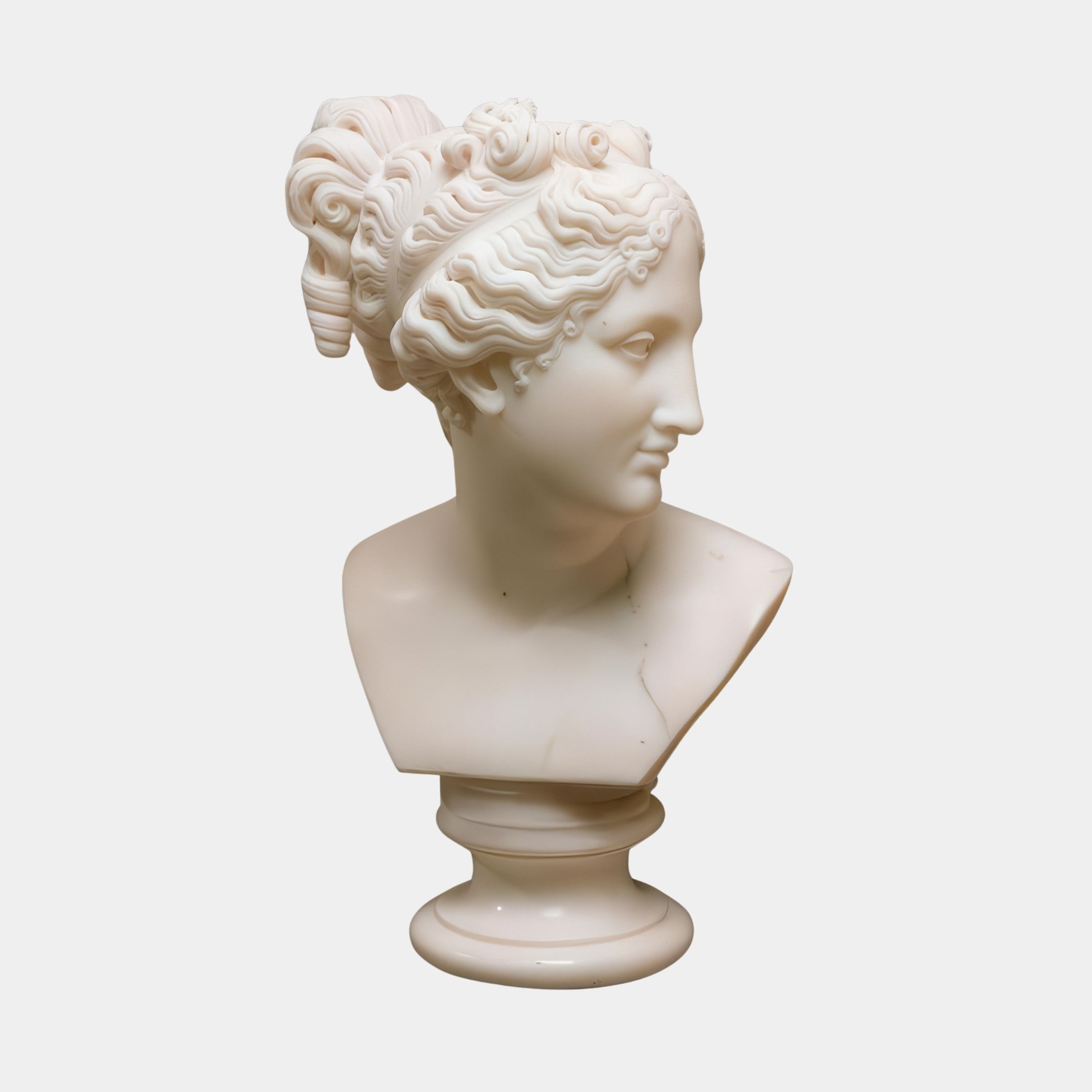The Venus Marble Bust Sculpture - 65cm by Giant Sculptures features a woman with wavy hair in an updo, facing right, and rests on a round pedestal—a striking decorative piece for any setting.