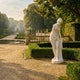 Giant Sculptures' 160cm Standing Nude Bather marble sculpture leaning forward with draped cloth, displayed beside a clipped hedge in a formal classical garden.