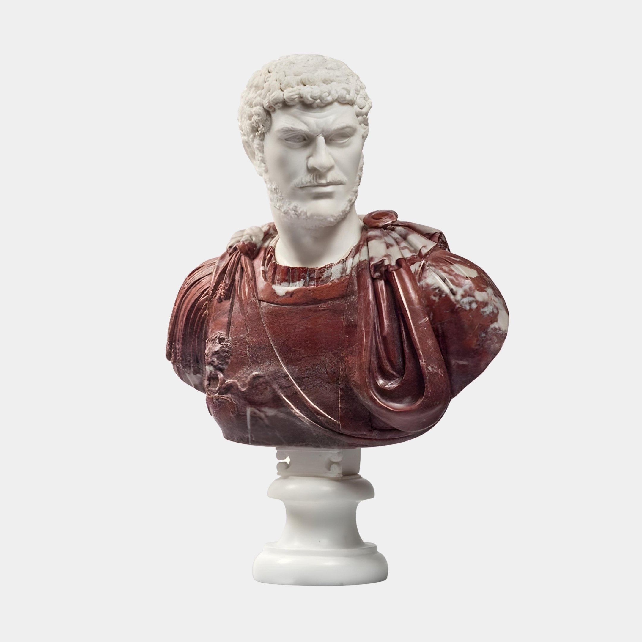 The Roman Male Marble Bust Sculpture - 75cm by Giant Sculptures features a two-tone marble and red stone design, depicting a curly-haired man with a stern expression and draped garment on a round white pedestal.