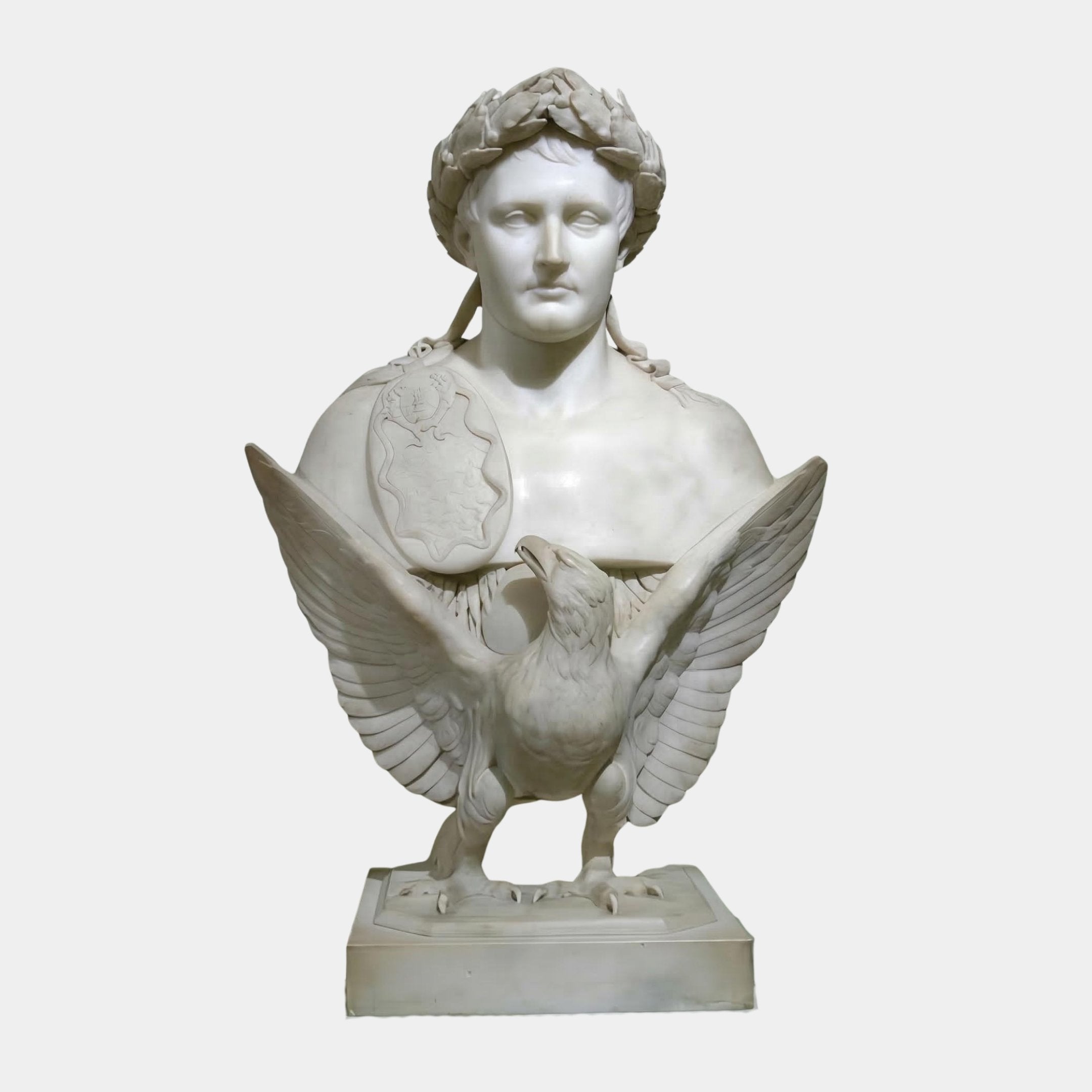 The Victory Marble Bust Sculpture With Eagle by Giant Sculptures (85cm) features a stern-faced figure adorned with a laurel wreath and medallion, with an intricately detailed eagle perched on the base, symbolizing triumph.