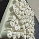 A close-up of white cylindrical forms, arranged in a neat pattern on an angled surface—ideal as the Harmonia 3D Spiral Wall Sculpture With Black Frame by Giant Sculptures, perfect for modern interiors. The background is blurred.