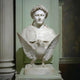 The Giant Sculptures Victory Marble Bust Sculpture With Eagle (85cm) depicts a man with a laurel wreath, an eagle spreading its wings in front, and a carved shield on the left shoulder, displayed against a paneled wall.