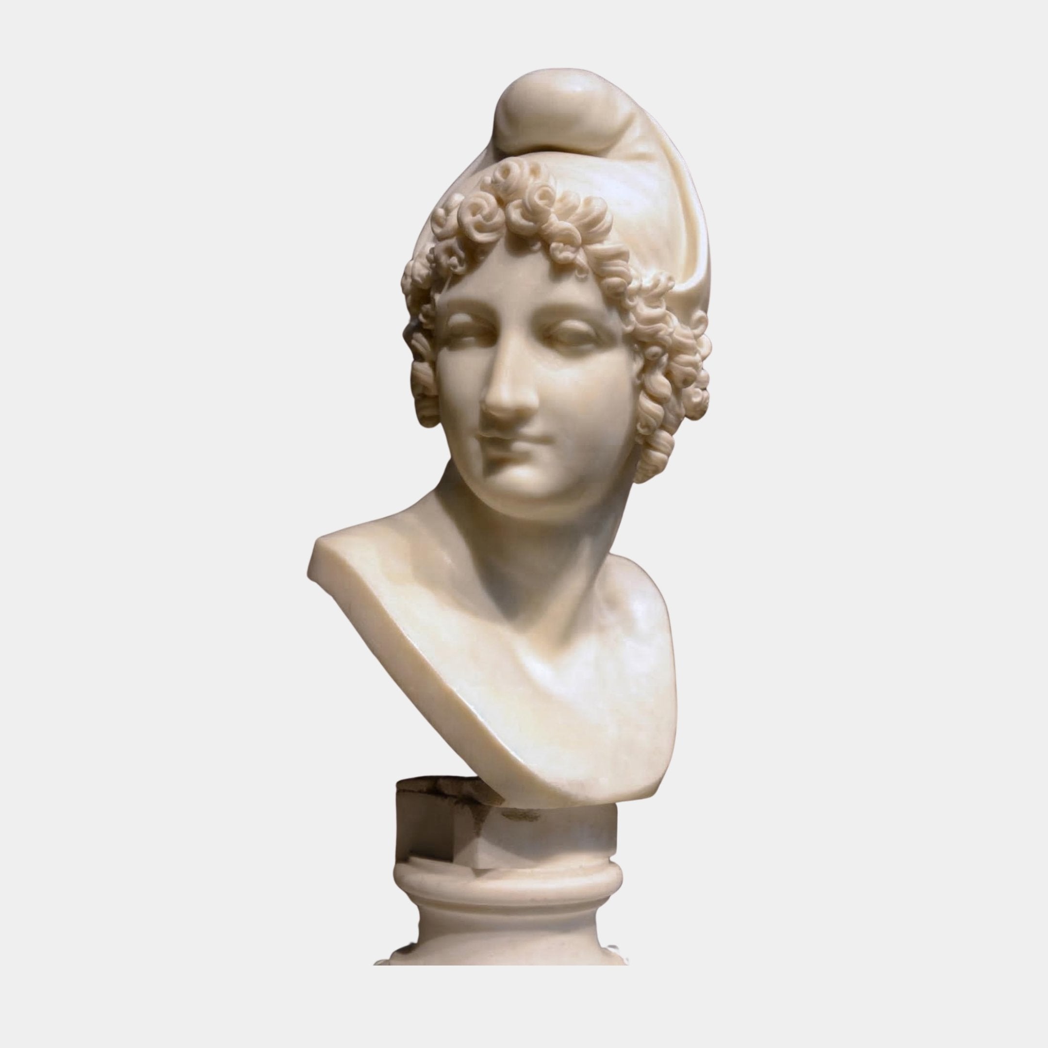 The Female Marble Bust With Cap Sculpture (50cm) by Giant Sculptures features a natural white marble bust of a woman with curled hair and cap, posed slightly left, and elegantly displayed on a pedestal.