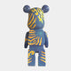 The Inside Appears Outside 2 Bear Sculpture by Giant Sculptures (135cm) is hand-painted in blue with orange and yellow swirls plus green dots on its back, standing upright and facing away from the viewer.