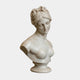 The Aphrodite Marble Bust Sculpture by Giant Sculptures is a 65cm white marble figure with wavy hair pinned up, a serene expression, and draped shoulders, set on a round pedestal base against a plain background.