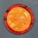 Galaxia Sun Crystal Porcelain LED Wall Art by Giant Sculptures mounted on a grey wall, displaying a glowing circular sun design in amber, orange, and deep red tones with a visible power cord.