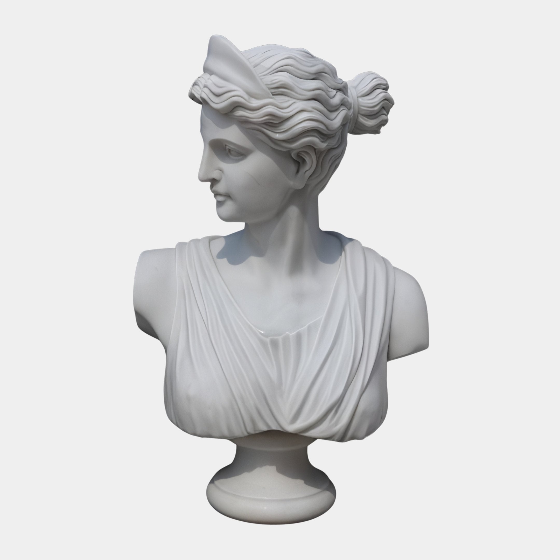 The Diana Marble Bust Sculpture (65cm) by Giant Sculptures features a woman with wavy hair pulled back and draped attire, gazing left. Its detailed classical design captures timeless femininity against a plain background.