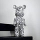 The limited edition Scribble Bear Sculpture - 50cm by Giant Sculptures stands against a white background adorned in complex black graffiti-like patterns. This piece of contemporary art rests on a black platform, captivating viewers with its abstract and artistic design.