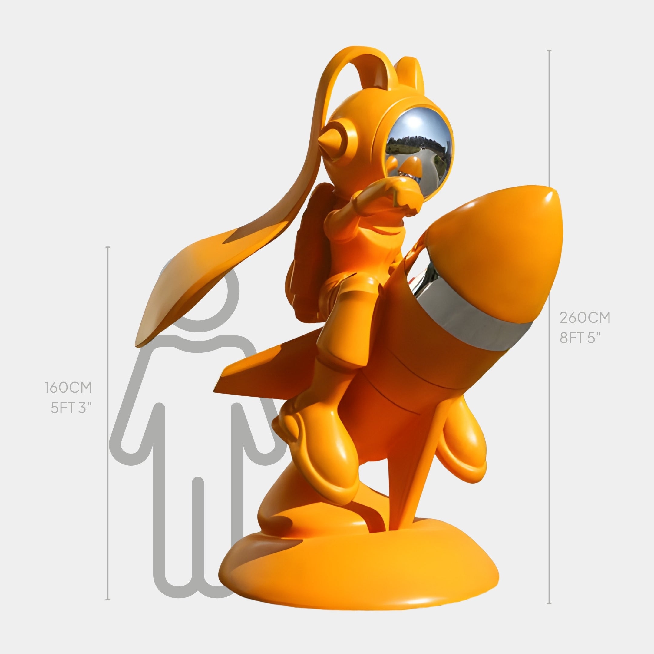 The Orange Cosmo Cat Rocket Rider Sculpture - 260cm by Giant Sculptures features a cat astronaut with a reflective helmet riding an orange rocket, towering 260 cm (8 ft 5 in) next to a 160 cm (5 ft 3 in) human silhouette.
