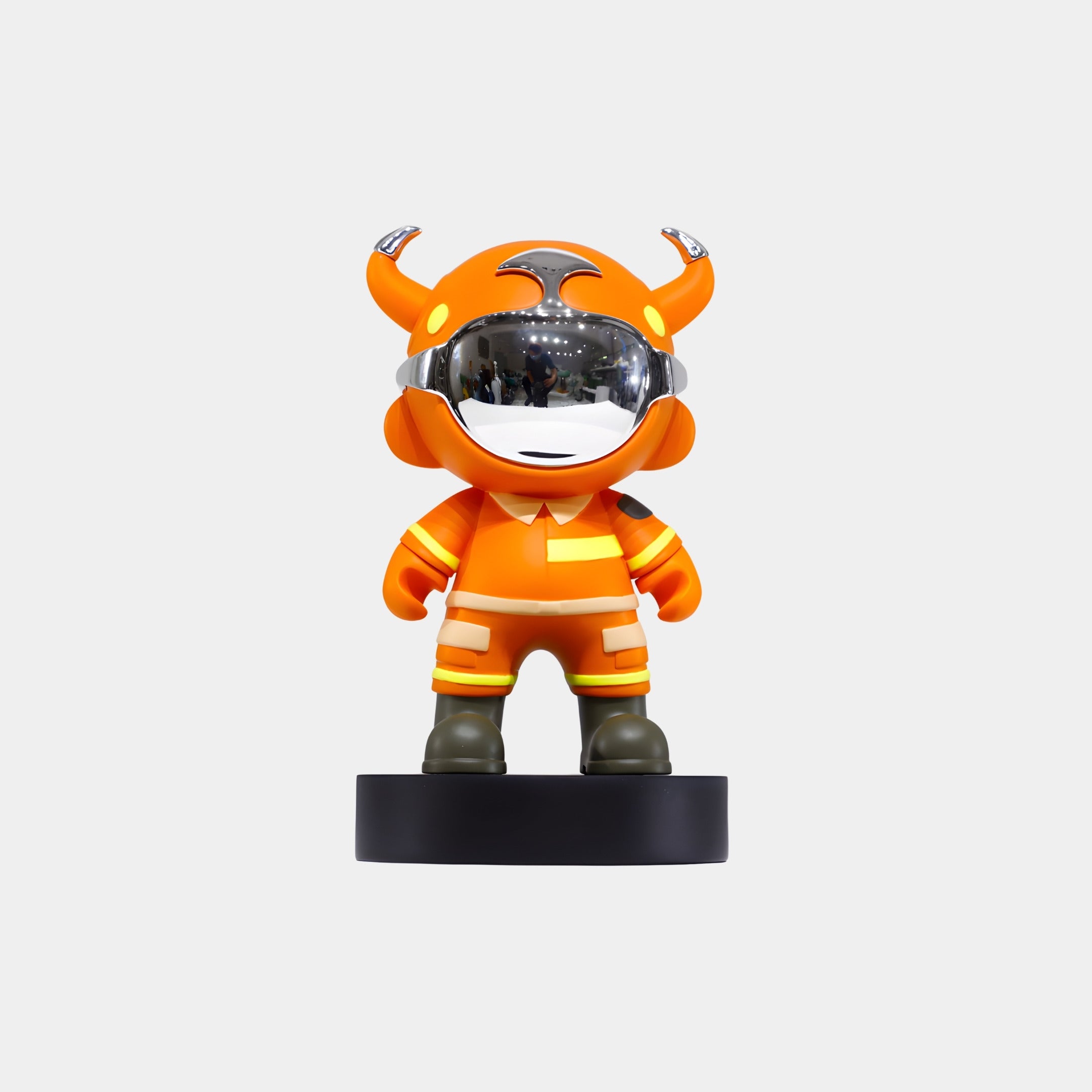 The Giant Sculptures Orange Utility Astro Devil Figure - 15cm features a chibi resin character in an orange suit with yellow accents, green boots, and a horned helmet, standing on a round black base against a white background.