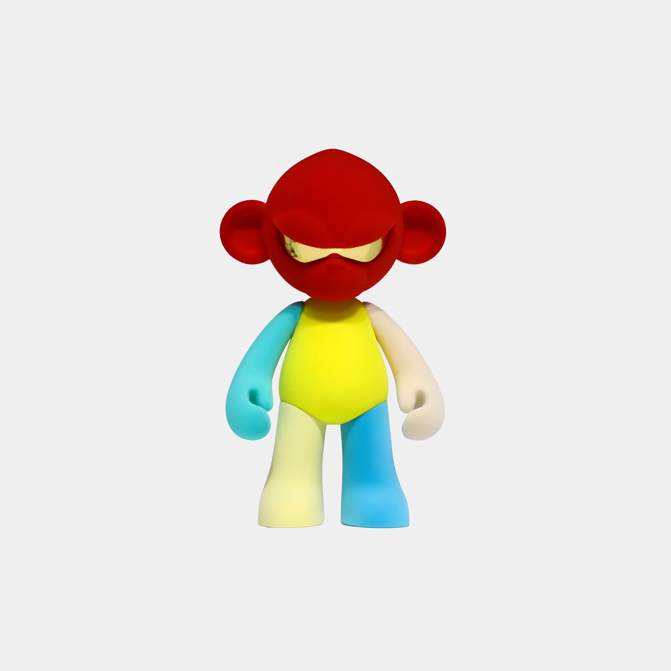 The Giant Sculptures Red Head Colorblock Monkey Figure - 15cm features a serious expression, yellow torso, blue and white arms, and blue and yellow legs. This collectible sculpture stands out against a plain gray background.