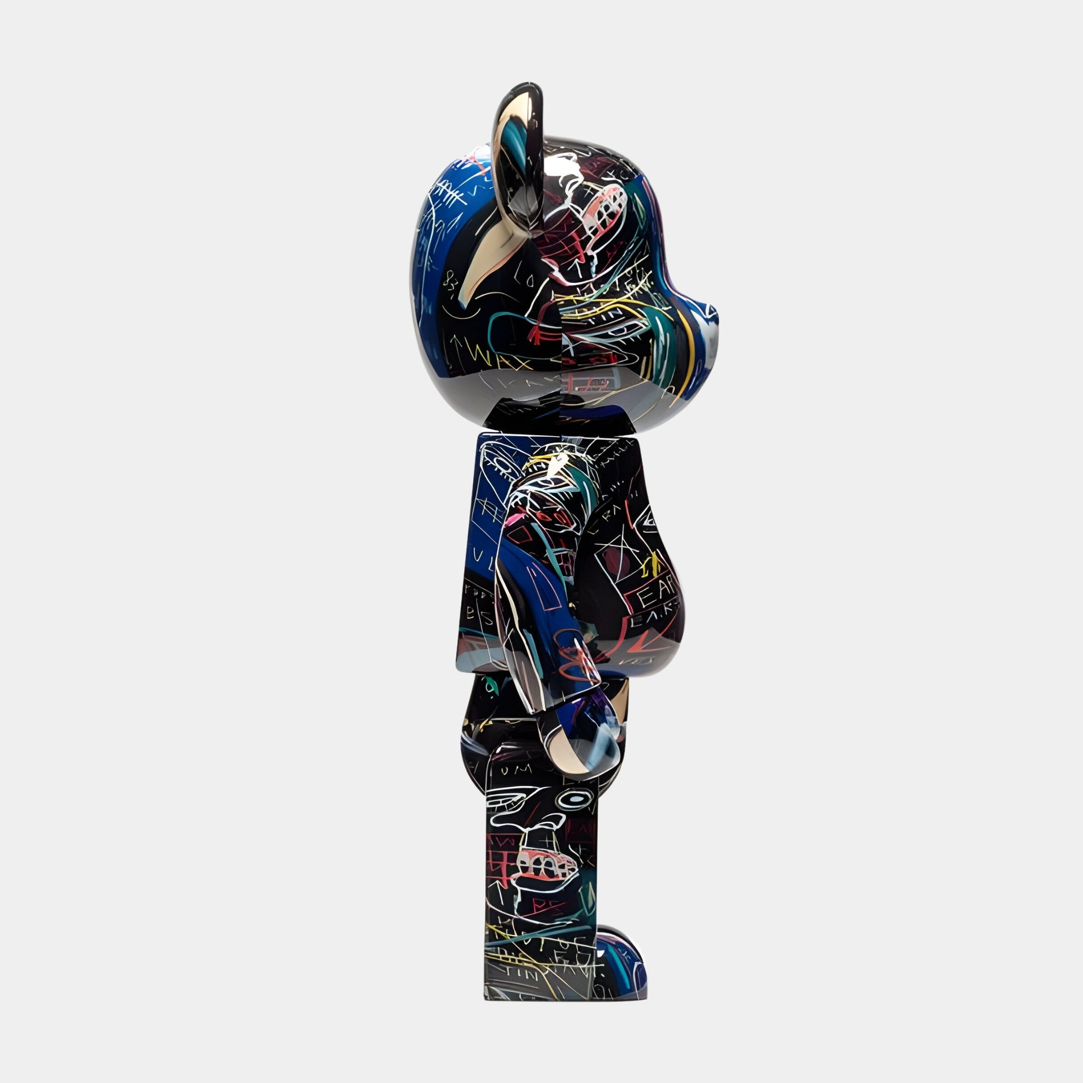 A side view of the Giant Sculptures Abstract Graffiti Bear Sculpture - 70cm, a limited edition designer toy with vibrant neo-expressionist tags on its glossy black finish, standing upright against a plain light background.