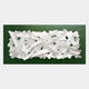 Stravira Green II Sculptural White Metal 3D Wall Art featuring overlapping white metal strips layered over a deep green background, viewed from the front against a light grey wall.