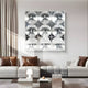 A modern living room with a light gray sofa and chic decor, featuring the Haloid I Bubble Grid Acrylic 3D Wall Art by Giant Sculptures—a striking array of nine shiny mirrored spheres arranged in a grid above the sofa.