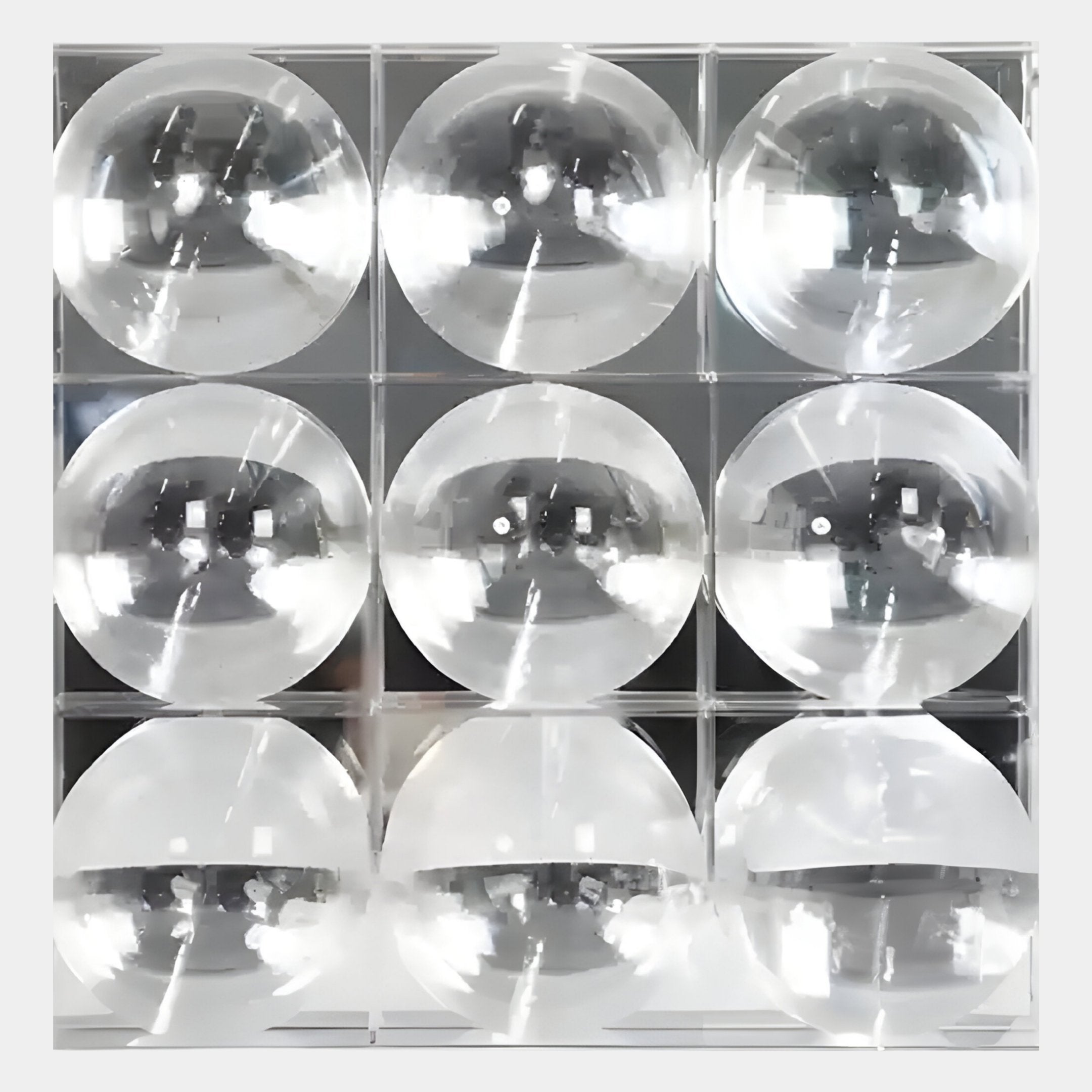 The Haloid I Bubble Grid Acrylic 3D Wall Art by Giant Sculptures features nine clear, dome-shaped lenses in a 3x3 grid, reflecting light and shadows for an eye-catching display against a gray background.