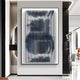 The Nebula II Midnight Swirl Acrylic 3D Wall Art by Giant Sculptures, featuring vertical blue, gray, and white ridges, hangs on a white wall in a sleek, minimalist contemporary space.